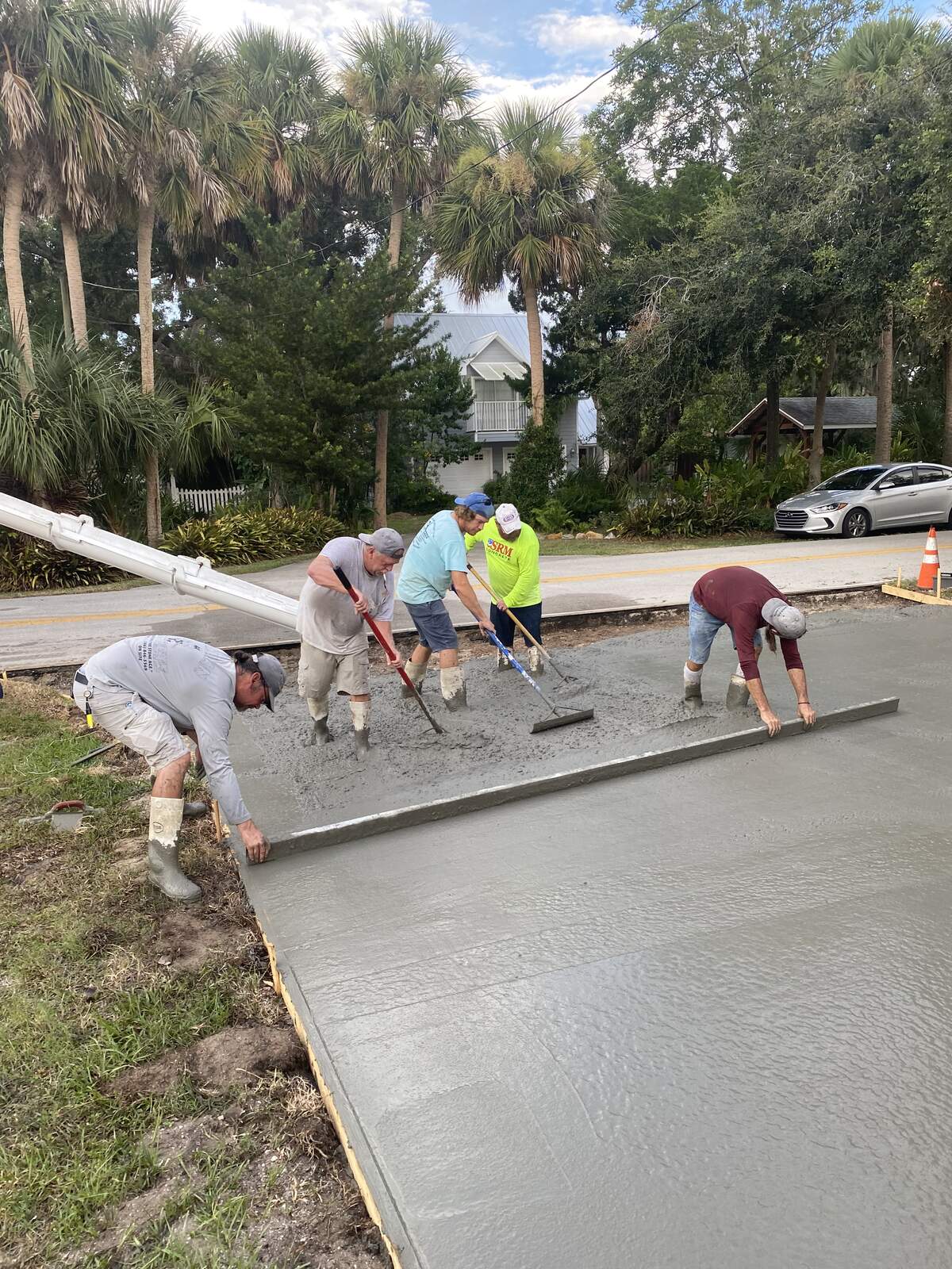 Caveman Concrete crew finishing a freshly poured driveway